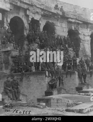 I soldati stanno sulle rovine di un'arena, costruita dai romani tra gli anni 138 e 150 d.C., per guardare i soldati giocare una partita di baseball; Nimes, Gard, France ca. 1919 Foto Stock