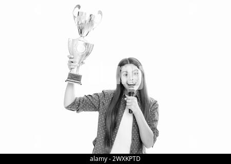 Ragazza adolescente con conversazione microfono della tazza di vincita. Teen in possesso di un trofeo. Il bambino vincitore ha vinto il concorso, celebrando il successo e la vittoria. Foto Stock