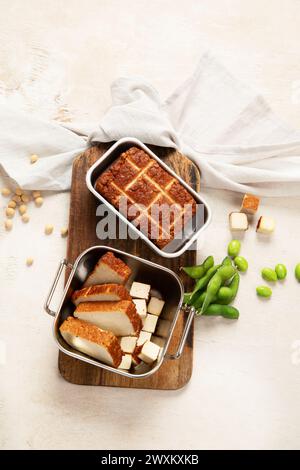 Cibo di soia. Tofu al forno su tavola, semi di soia. Prodotto vegano. Vista dall'alto Foto Stock