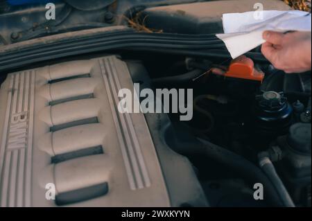 Un uomo che si pulisce la faccia con un motore Foto Stock