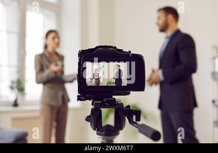 Videocamera digitale professionale per la registrazione di podcast video in diretta su un giovane uomo e una donna in studio Foto Stock