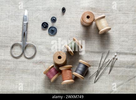 aghi con filo da cucire e forbici su tela Foto Stock