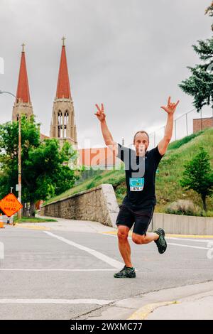 Uomo eccitato che corre alla Governor's Cup Race con la cattedrale alle sue spalle Foto Stock