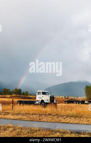 Scena rurale del Montana con arcobaleno sopra un antico camion bianco Foto Stock