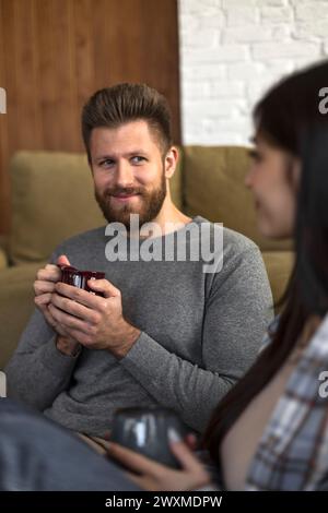 il giovane uomo sorride sentimentalmente alla donna amata Foto Stock