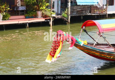 Ghirlande di fiori appese sulla prua tailandese della barca a coda lunga per l'offerta alla dea Mae Ya Nang Foto Stock