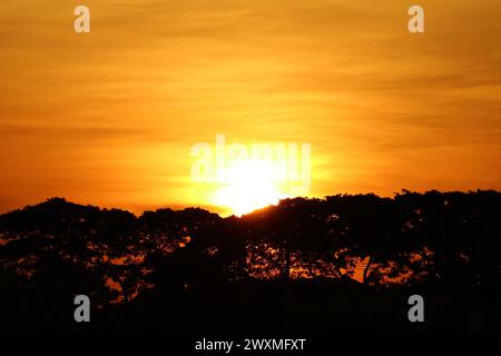 Splendido sole luminoso che tramonta sullo splendido cielo dorato Foto Stock