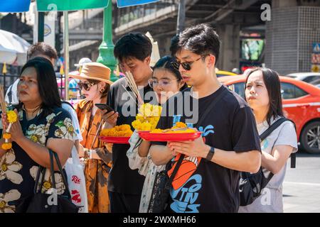 Bangkok, Thailandia. 30 marzo 2024. Thailandesi e turisti sono visti pregare al santuario di Erawan, nel centro di Bangkok. Il Santuario di Erawan, dedicato al dio Brahma, è un luogo venerato dove i visitatori dalla Thailandia e da tutto il mondo offrono incenso, ghirlande, frutta e statue di elefanti, sperando che i loro desideri si avverino. Inoltre, il santuario contribuisce a cause caritative, fornendo sostegno agli ospedali e alle organizzazioni in tutta la Thailandia. Credito: SOPA Images Limited/Alamy Live News Foto Stock