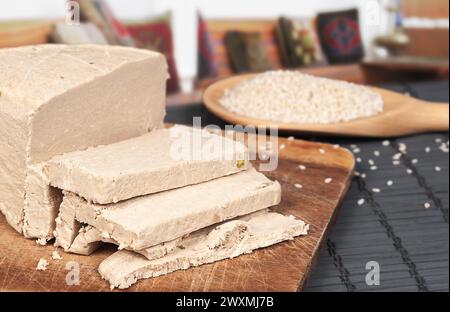 Tahini halva a fette, cucchiaio di legno con semi di sesamo da vicino Foto Stock