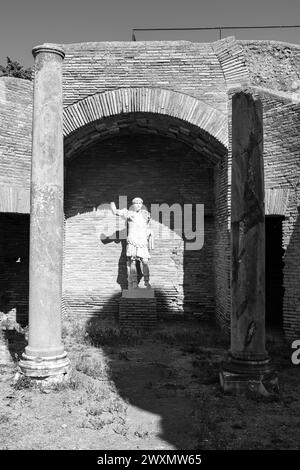 Foto in bianco e nero della statua rotta dell'imperatore romano all'interno delle rovine del parco archeologico dell'antica Ostia Foto Stock