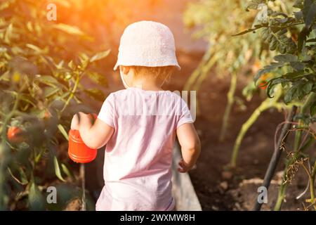 Una bambina carina tiene il giocattolo in mano. Fiori d'acqua per bambini Foto Stock