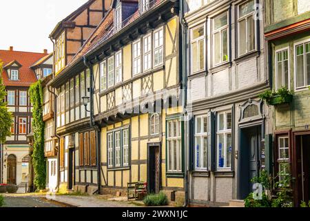 Case medievali in legno lungo la strada acciottolata nella storica Quedlinburg, Germania, sito patrimonio dell'umanità dell'UNESCO con architettura tradizionale Foto Stock