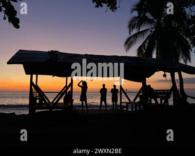 Persone al resort (Poor Man's Paradise) che guardano il tramonto vicino a Drake Bay, Playa San Josecito, la penisola di osa, Costa Rica Foto Stock