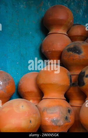 le pentole sono raccolte e disposte in uno schema nello spazio vuoto. Il vasaio lavora su una ruota di ceramica realizzata in argilla dai colori tenui, in stile retrò con tonalità Cl Foto Stock