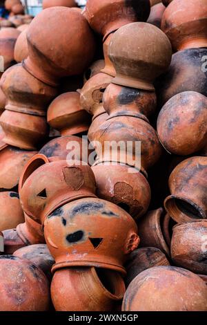 le pentole sono raccolte e disposte in uno schema nello spazio vuoto. Il vasaio lavora su una ruota di ceramica realizzata in argilla dai colori tenui, in stile retrò con tonalità Cl Foto Stock