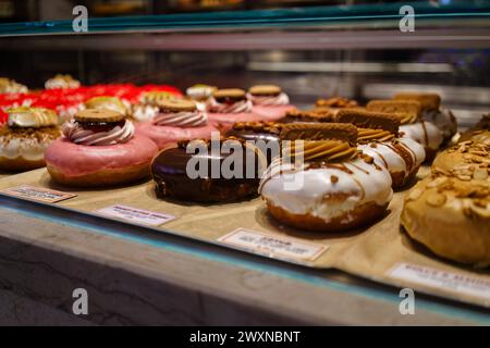 Doughnut Gourmet assortite in mostra presso una vetrina di prodotti da forno nel mercato Time Out. Lisbona, Portogallo. 2 febbraio 2024. Foto Stock