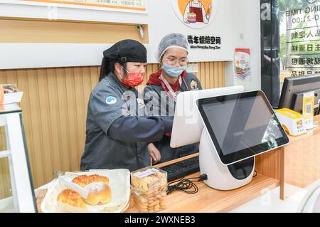 (240401) -- SHENZHEN, 1° aprile 2024 (Xinhua) -- i giovani autistici Yuan Anqi (L) e Qiu Minyi, lavorano in un panificio a Shenzhen, nella provincia del Guangdong della Cina meridionale, 21 marzo 2024. Yuan Anqi, 22 anni, e Qiu Minyi, 28 anni, sono cassieri della panetteria dal giugno 2023. Con l'aiuto del loro insegnante, potevano anche fare pane e torte a volte. Questo martedì segna la diciassettesima giornata mondiale della consapevolezza dell'autismo. Nella Shenzhen del sud della Cina, alcuni giovani autistici, chiamati "figli delle stelle", si sono integrati nella società e stanno inseguendo i loro sogni. Negli ultimi anni, i bambini autistici in Cina hanno guadagnato l'incr Foto Stock