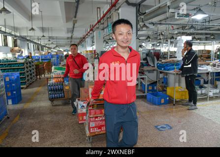 (240401) -- SHENZHEN, 1° aprile 2024 (Xinhua) -- i giovani autistici Huang Xuanning (L) e Cao Hongyi lavorano in un parco industriale a Shenzhen, nella provincia del Guangdong della Cina meridionale, 21 marzo 2024. Huang Xuanning, 24 anni, e Cao Hongyi, 27 anni, si unirono al parco industriale nel settembre 2023. Sono responsabili del caricamento dei distributori automatici nell'area della fabbrica, inclusa la movimentazione e il posizionamento di snack e bevande. Ora sono fondamentalmente qualificati per il lavoro con l'aiuto dei partner del team. Questo martedì segna la diciassettesima giornata mondiale della consapevolezza dell'autismo. Nella Shenzhen del sud della Cina, alcuni giovani autistici, che venivano chiamati 'bambini Foto Stock