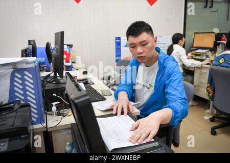 (240401) -- SHENZHEN, 1° aprile 2024 (Xinhua) -- dai Jinyu, un giovane autistico di 29 anni, lavora presso la Shenzhen Autism Society a Shenzhen, nella provincia del Guangdong della Cina meridionale, 27 marzo 2024. Dai Jinyu è entrato a far parte dell'organizzazione nell'ottobre 2018, principalmente responsabile della scansione e della copia dei file e della disinfezione degli interni. Questo martedì segna la diciassettesima giornata mondiale della consapevolezza dell'autismo. Nella Shenzhen del sud della Cina, alcuni giovani autistici, chiamati "figli delle stelle", si sono integrati nella società e stanno inseguendo i loro sogni. Negli ultimi anni, i bambini autistici in Cina hanno guadagnato crescente attenzione e.. Foto Stock