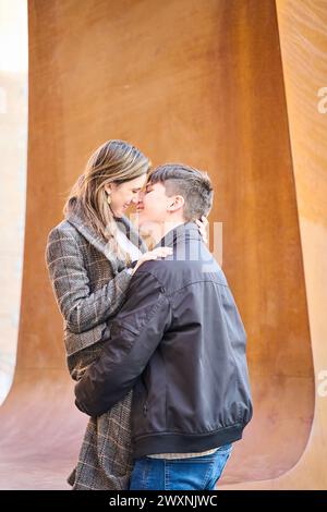 una giovane coppia si baciano e si abbracciano per strada. la coppia festeggia san valentino con passione Foto Stock