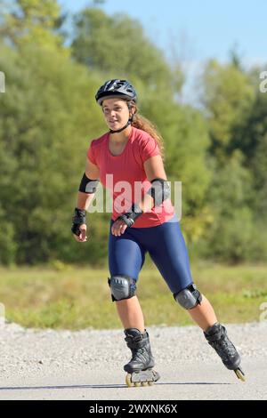 Giovane donna con i rollerblade in tarda estate Foto Stock