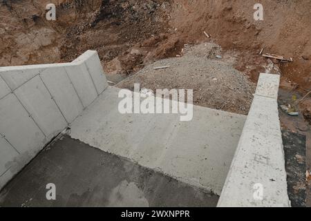 Soletta di cemento di fronte a un'area di costruzione scavata Foto Stock