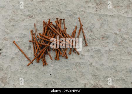 Chiodi assortiti sparsi su superfici in calcestruzzo Foto Stock