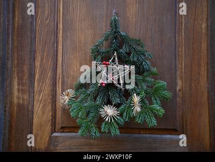 Decorazioni natalizie sempreverdi su un'antica porta in legno a Kaysersberg, Alsazia, Francia. Foto Stock