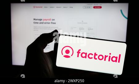 Persona che possiede uno smartphone con il logo della società spagnola Everyday software S.L. (HR fattoriale) davanti al sito web. Mettere a fuoco il display del telefono. Foto Stock