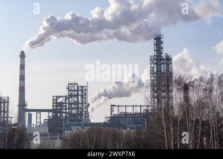 Il lavoro di un impianto petrolchimico. Il fumo proviene dal camino. Foto Stock