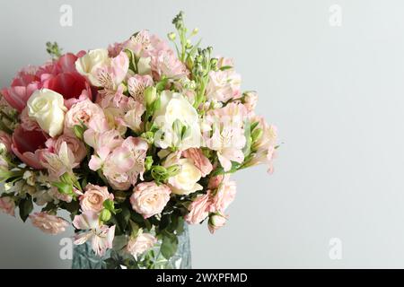 Bellissimo bouquet di fiori freschi in vaso su sfondo chiaro. Spazio per il testo Foto Stock