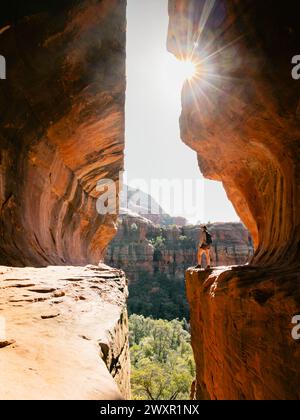 Bagliore del sole al mattino presto alla Secret Subway Cave Boynton Canyon Sedona con una sola escursionista. Foto Stock