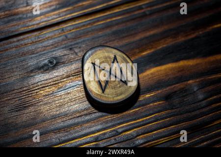 Rune Dagaz scolpito in legno su fondo in legno - Elder Futhark Foto Stock