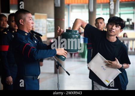 Bangkok, Thailandia. 1 aprile 2024. Un uomo thailandese estrae una lotteria durante una bozza militare annuale al Wat Samakkhitham di Bangkok. Le forze Armate reali tailandesi hanno lanciato il loro progetto annuale di coscrizione militare a partire dal 1 aprile 2024 al 12 aprile 2024 alla ricerca di uomini sani da 21 anni in su provenienti da tutto il paese, volontariamente e disegnando una lotteria. Credito: SOPA Images Limited/Alamy Live News Foto Stock