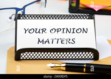 LA SUA OPINIONE CONTA LA frase scritta su un biglietto da visita sul tavolo Foto Stock