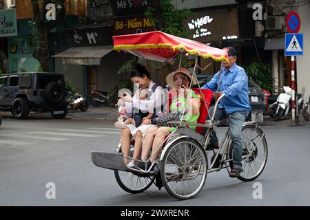 Gita in bicicletta con la famiglia nel centro storico di Hanoi, Vietnam Foto Stock