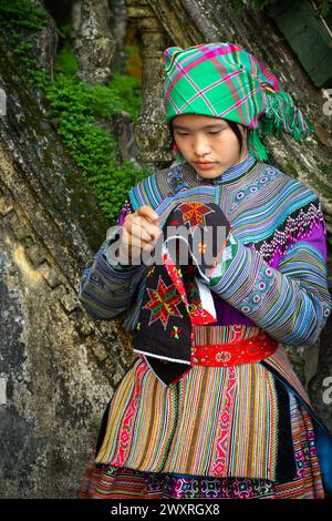 Donna Hmong di fiori che fa ricami al Palazzo dei Re Hmong (Vau Meo) a Bac ha, provincia di Lao Cai, Vietnam Foto Stock