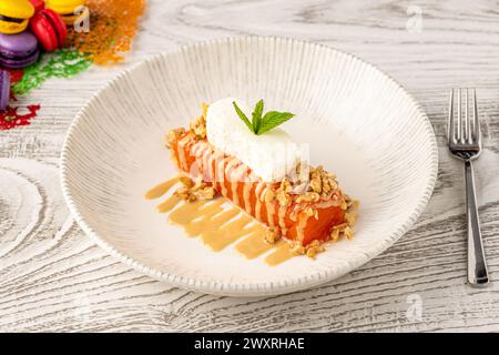 Dessert di zucca con tahini e noci su un piatto di porcellana Foto Stock