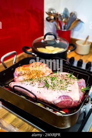 Preparare una gamba e una piccola spalla di agnello per tostare con aglio ed erbe di rosmarino Foto Stock