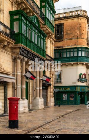 La Valletta, Malta - 23 dicembre 2023: Tipica strada del centro di la Valletta con verdi balconi Gallarija e influenze britanniche Foto Stock