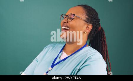 Giovane donna nera lavoratrice sanitaria ridendo, profilo laterale Foto Stock