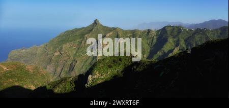 L'alba si rompe su una aspra catena montuosa, gettando ombre e illuminando picchi sotto un cielo limpido. Tenerife, Spagna Foto Stock