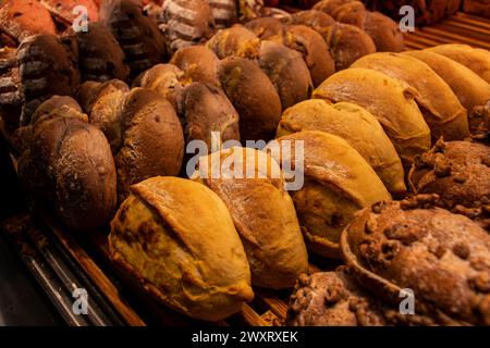 Uno shot ravvicinato di una varietà di pane e pasticcini esposto su uno scaffale da forno Foto Stock