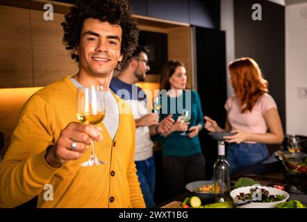Ritratto di un uomo con un bicchiere di vino a cena con gli amici a casa. Foto Stock