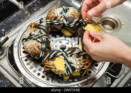 signora che prepara i granchi e a proposito del vapore Foto Stock