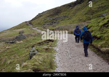 Due uomini (escursionisti) che camminano in salita su un percorso dal lago artificiale Scar House a Middlesmoor sulla Nidderdale Way, Yorkshire Dales National Park, Inghilterra, Regno Unito. Foto Stock