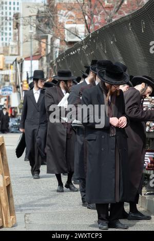 In un caldo giorno primaverile gli ebrei ortodossi fanno acquisti in un negozio pop-up che vende libri religiosi. Sul cavalcavia BQE a Brooklyn, New York. Foto Stock