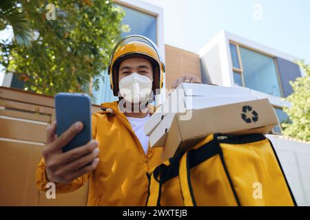 Uomo sorridente che indossa una maschera protettiva durante il lavoro Foto Stock