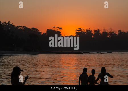 30/03/24-Manyana Beach al tramonto, 214 km a sud-ovest di Sydney, NSW, Australia. Sagome della gente del posto che si rilassa. Manyana Beach parte dal villaggio di Manyana Foto Stock