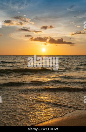 Il sole tramonta sull'oceano con nuvole nel cielo. Naples Beach, Florida Foto Stock